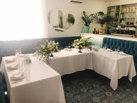 two tables in a restaurant with white flowers on them at Biruza Club in Svyatopetrivske