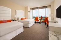 ein Hotelzimmer mit zwei Betten und einem Tisch und Stühlen in der Unterkunft Scarlet Pearl Casino Resort in Biloxi