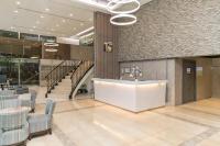 a lobby with chairs and a counter and stairs at Hotel Leisure Beitou in Taipei