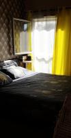 a bedroom with a bed with a yellow curtain and a window at Chambre et salle de bain privée proche Paris et Disney in Limeil-Brévannes