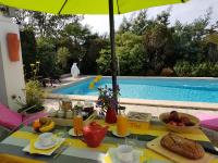 a table with food and an umbrella next to a swimming pool at Les Yeux Bleus Bed &amp; Breakfast in Noirmoutier-en-l&#39;lle