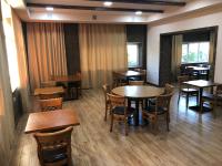 uma sala de jantar com mesas e cadeiras de madeira em Vanadzor Armenia Hotel em Vanadzor