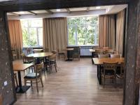 uma sala de jantar com mesas, cadeiras e janelas em Vanadzor Armenia Hotel em Vanadzor