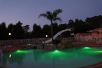 a swimming pool at night with a roller coaster at Résidence Les Castors in Calvi