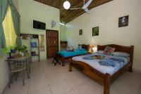 a bedroom with a bed and a table in it at Hotel Sunshine Caribe in Puerto Viejo