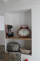 a clock sitting on a shelf in a kitchen at Maison au pied de la cathédrale in Elne