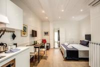 a room with a bed and a kitchen with a table at Colosseo Suite Apartment in Rome