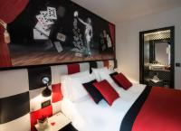 a bedroom with a bed with red and black pillows at Hotel Splendor Elysées in Paris