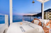 un restaurante con mesas blancas y vistas al océano en Il Cefalo Hotel & Restaurant, en Castellabate