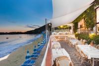 un restaurante en la playa con mesas y sillas en Il Cefalo Hotel & Restaurant, en Castellabate