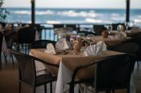 Una mesa con copas de vino y servilletas y el océano. en Velero Beach Resort, en Cabarete