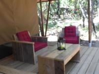 two chairs and a table on a wooden deck at Camping Mille Étoiles in Labastide-de-Virac