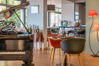 un restaurante con mesa y piano en Les Jardins du Cèdre, Boutique hôtel & gastronomie, en Port-Vendres