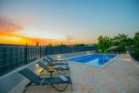 a swimming pool with lounge chairs and a swimming pool at Villa &quot;Mile&quot; in Katuni