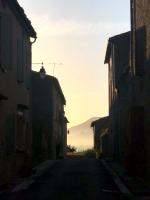 an alley with buildings and the sunset in the distance at Maison Marie in Lagarde