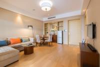 ein Wohnzimmer mit einer Couch und einem Tisch in der Unterkunft Pinxiayuan Apartment in Lvcheng Resort in Zhoushan