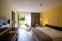 a hotel room with a large bed and a living room at Heide Spa Hotel &amp; Resort in Bad Düben
