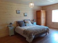 a bedroom with a bed in a room with wooden walls at LES TROIS CHARMES in Chaucenne