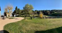 un parc verdoyant avec un arbre et un trottoir dans l&#39;établissement Mas de guffiage, à Bollène