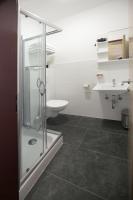 a bathroom with a shower and a toilet and a sink at F Hotel in Hörsching