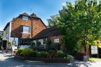 a building with a tree and flowers in front of it at The Black Horse Inn in Maidstone
