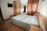 Un dormitorio con una cama blanca y suelos de madera. en Hotel Padre Cruz, en Valença