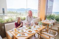 una mujer y un niño sentados en una mesa en un restaurante en TMS Hotel Da Nang Beach, en Da Nang