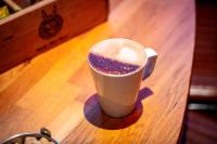 a cup of coffee sitting on top of a table at Kick Ass Greyfriars (18+) in Edinburgh