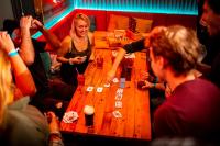 a group of people sitting around a table playing cards at Kick Ass Greyfriars (18+) in Edinburgh