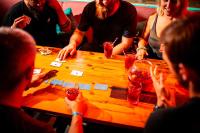 a group of people sitting around a wooden table at Kick Ass Greyfriars (18+) in Edinburgh
