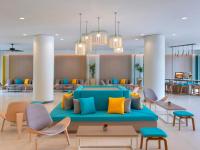 a lobby with a blue couch and tables and chairs at Ibis Phuket Patong in Patong Beach