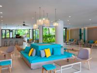 a living room with a blue couch and chairs at Ibis Phuket Patong in Patong Beach