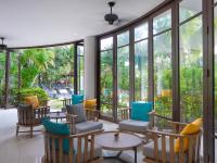 a lobby with chairs and tables and windows at Ibis Phuket Patong in Patong Beach