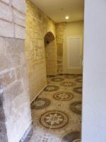 Habitación con pared de piedra y suelo de baldosa. en Angel&#39;s house, en Nazaret
