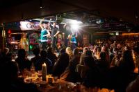 a crowd of people in a bar with performers on a stage at Arlington Hotel O'Connell Bridge in Dublin