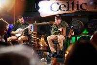a group of three men playing instruments on a stage at Arlington Hotel O'Connell Bridge in Dublin
