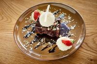 a plate with a piece of chocolate cake with whipped cream and strawberries at Arlington Hotel O'Connell Bridge in Dublin