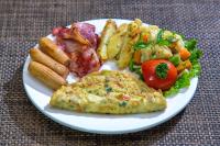 um prato de comida com ovos e vegetais em uma mesa em Kathmandu Suite Home em Catmandu