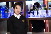 uma mulher em frente a um bar com garrafas de vinho em Kathmandu Suite Home em Catmandu