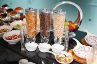 a table topped with three tall glass containers filled with food at Gloria Hotel Amman in Amman