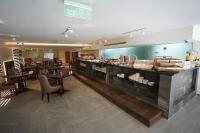 a restaurant with a counter with tables and chairs at Gloria Hotel Amman in Amman