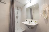 a white bathroom with a sink and a shower at Hotel Beauvoir in Paris