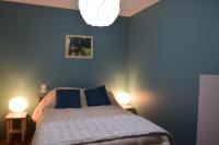 a bedroom with a bed with blue walls and two lamps at Maison éclusière Le Port, Les Refuges du Halage in Sacé