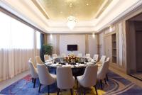 uma grande sala de jantar com mesa e cadeiras em Ramada Plaza by Wyndham Wenzhou em Wenzhou
