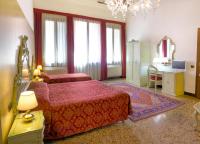 a bedroom with two beds and a table with a desk at Guesthouse Ca&#39; San Marcuola 1 in Venice