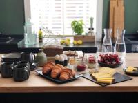 a table with croissants cheese and other foods on it at Konrads Limburg - Hotel &amp; Gästehaus in Limburg an der Lahn