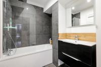 a bathroom with a tub and a sink and a shower at Appartement Croisé Laroche 40m2 in Marcq-en-Baroeul
