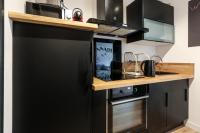 a kitchen with black cabinets and a counter at Appartement Croisé Laroche 40m2 in Marcq-en-Baroeul