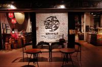 a restaurant with tables and chairs in front of a brick wall at Kim Haus Loft in George Town