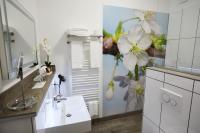 a bathroom with a sink and a flower mural on the wall at Hotel Garni am Schloss in Kottenheim